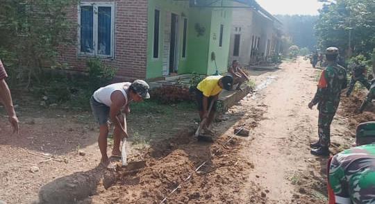 Babinsa Turut Serta Gotong Royong Membuat Parit Jalan Poros Desa Purwodadi